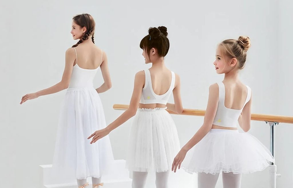 Three young ballet dancers in white tutu and Suyiyi training bras.